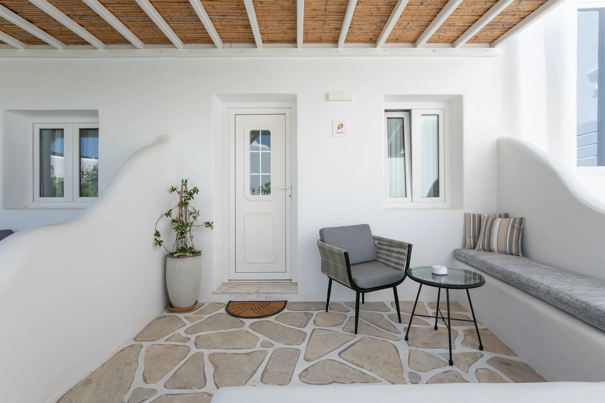 Deluxe Garden Suite · Private terrace of the Deluxe Garden Suite with grey armchairs on a stone floor